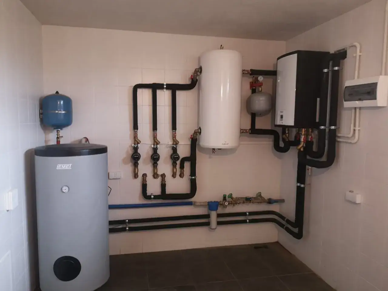 Instalacja grzewcza z zasobnikiem i nowoczesną pompą ciepła, gotowa do efektywnego ogrzewania domu.